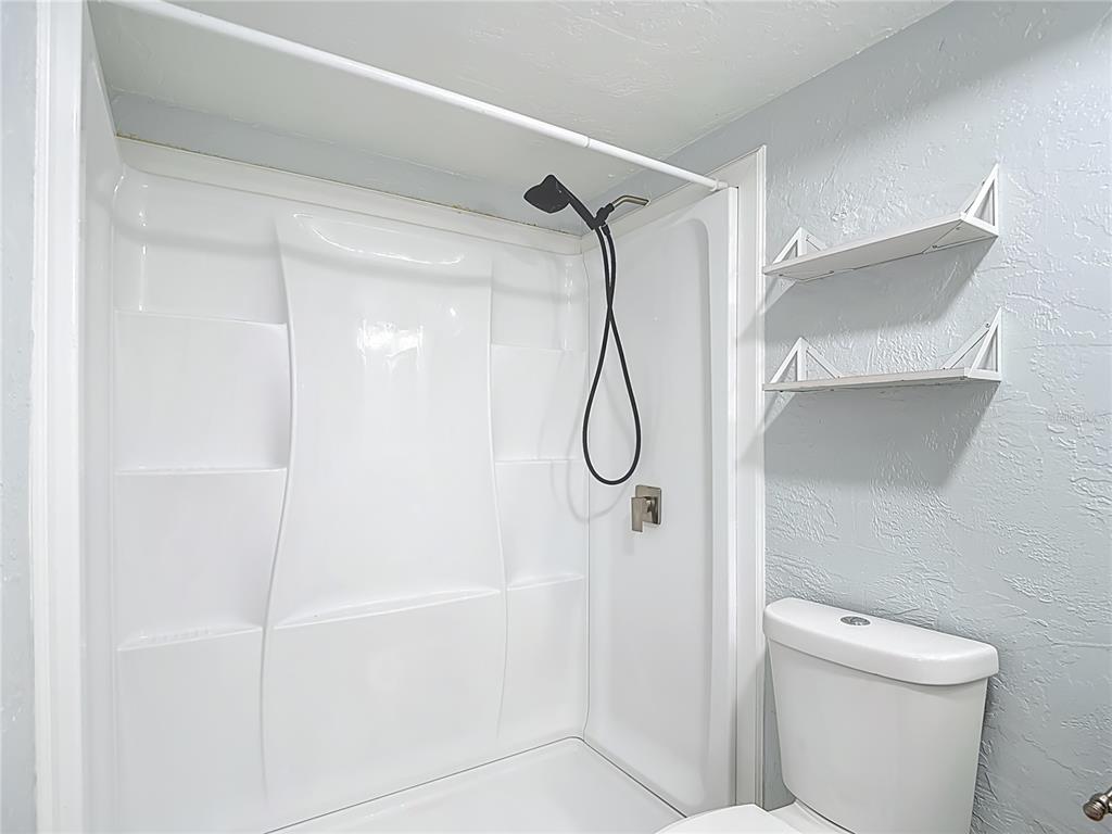 13156 Odham Street Spring Hill, FL 34609 - Photo 17 of 54 a bathroom with a shower and a toilet