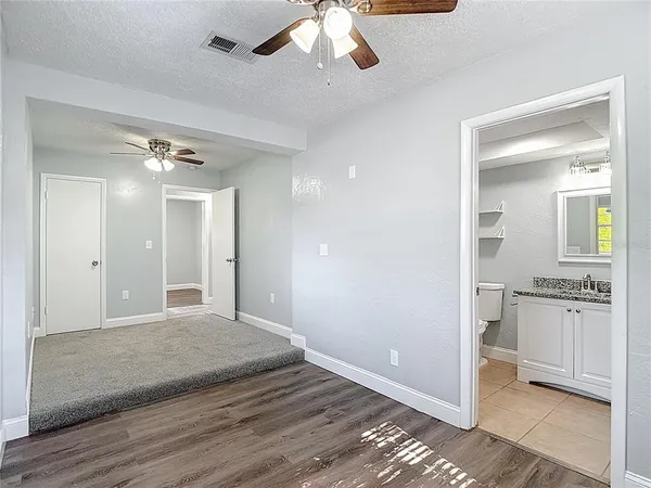an empty room with a empty space and chandelier fan