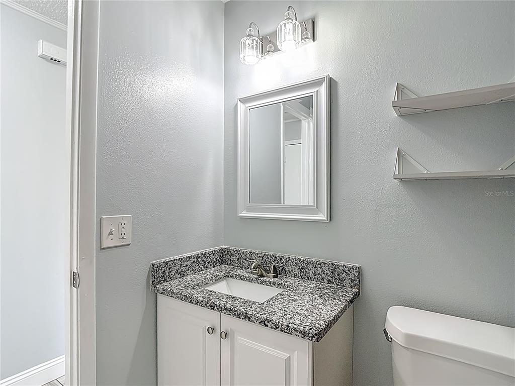 13156 Odham Street Spring Hill, FL 34609 - Photo 23 of 54 a bathroom with a granite countertop sink and a toilet