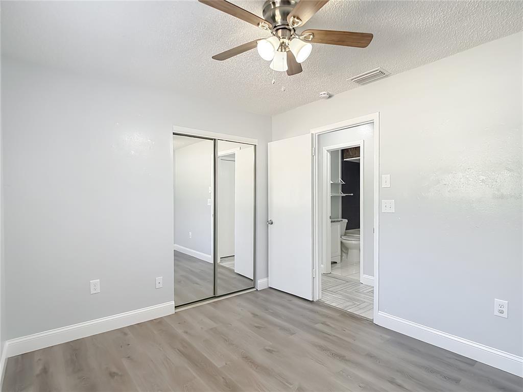 13156 Odham Street Spring Hill, FL 34609 - Photo 28 of 54 an empty room with wooden floor closet and ceiling fan
