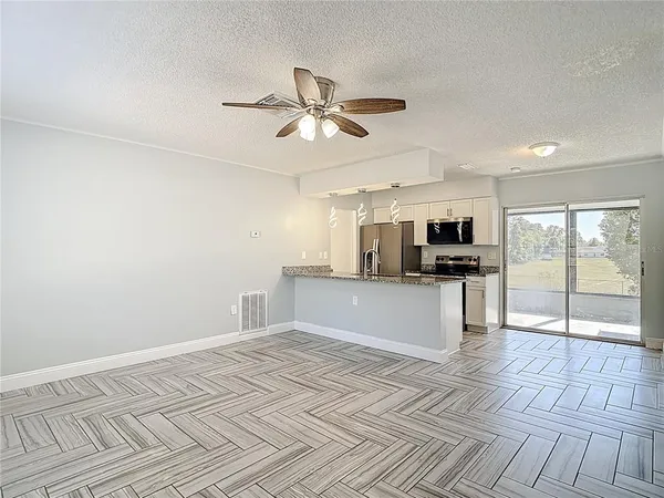 a view of kitchen with stainless steel appliances refrigerator stove and microwave