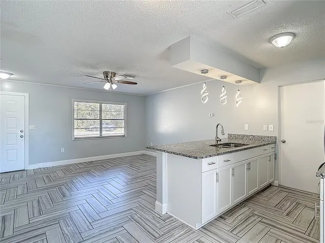 a kitchen with a sink and chandelier