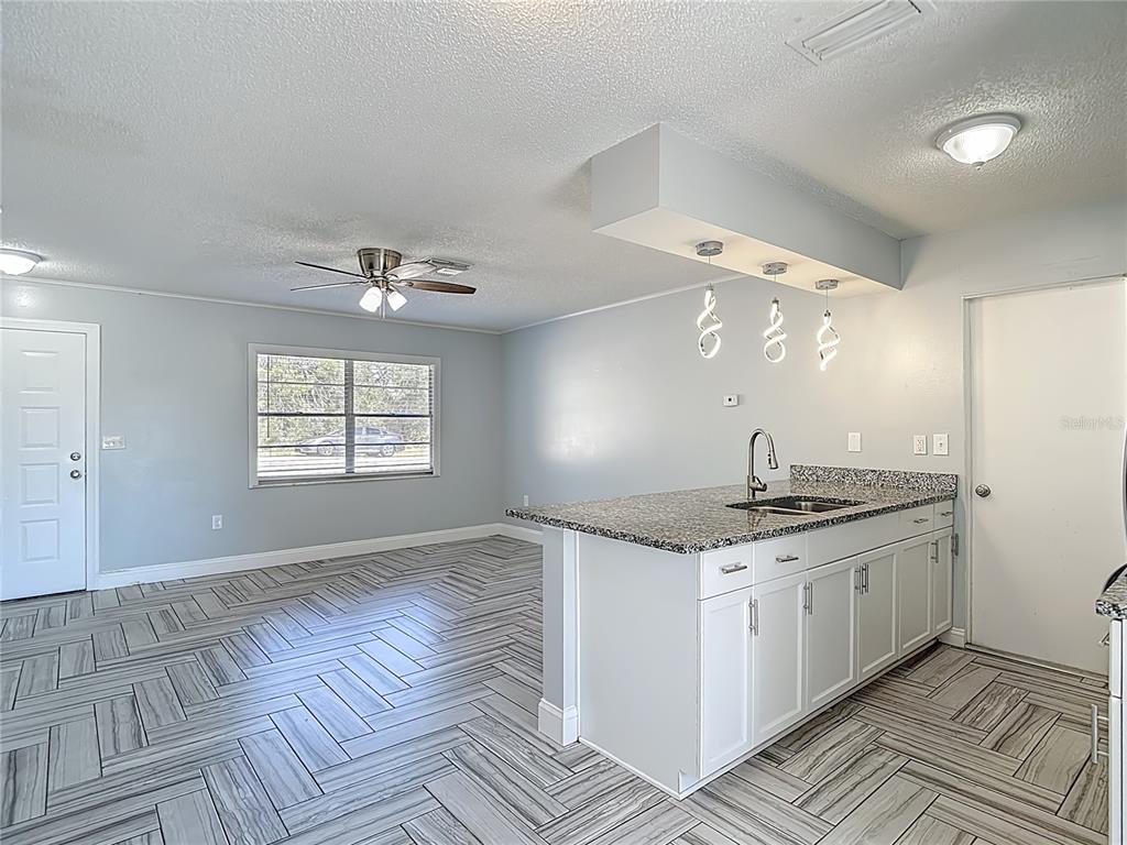 13156 Odham Street Spring Hill, FL 34609 - Photo 8 of 54 a kitchen with granite countertop a sink cabinets and wooden floor