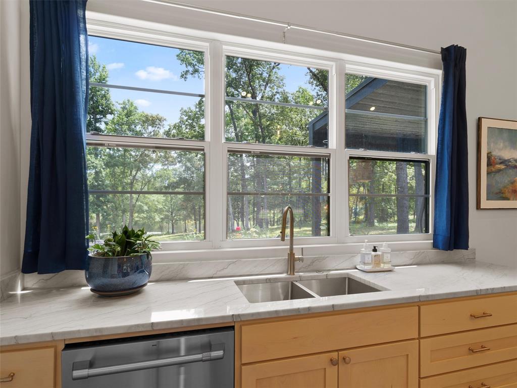 800 John Dean Road Gilmer, TX 75644 - Photo 18 of 40 a kitchen with a sink a large window with potted plants
