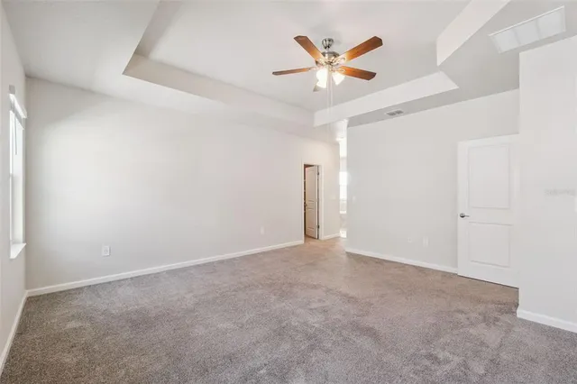 an empty room with a ceiling fan and a window