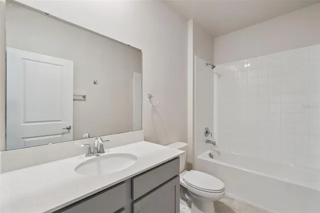 a bathroom with a granite countertop sink toilet a mirror and shower