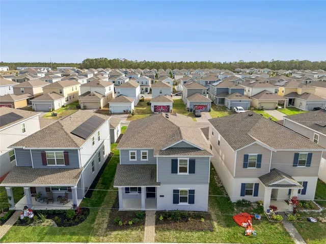 an aerial view of multiple houses with a yard