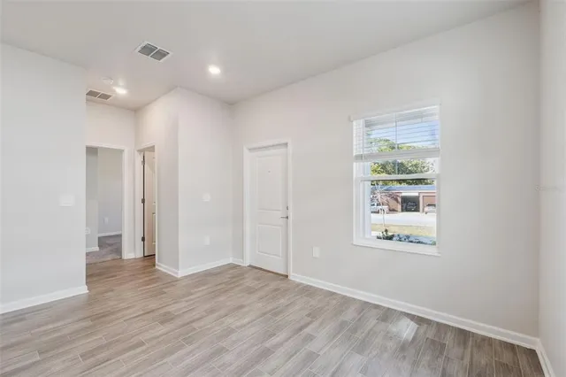 an empty room with wooden floor and a window