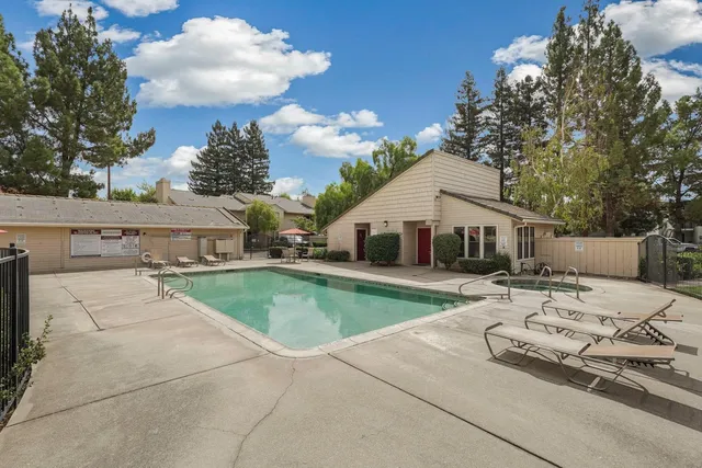a view of a house with pool and chairs