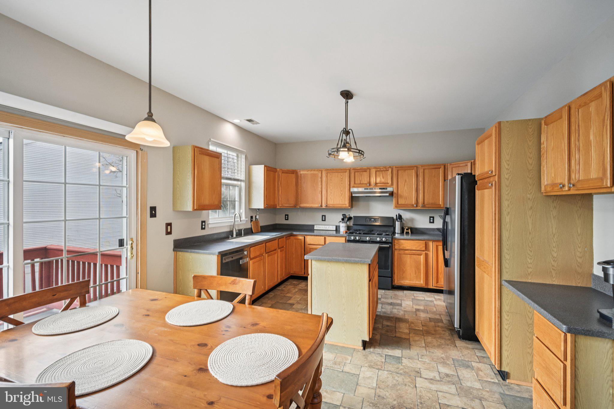 4 Cheyenne Court Burlington, NJ 08016 - Photo 8 of 34 a kitchen with stainless steel appliances kitchen island granite countertop a sink a stove a refrigerator a dining table and chairs
