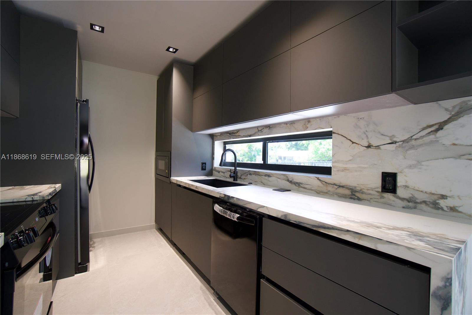 2155 Southwest 25th Terrace Miami, FL 33133 - Photo 13 of 20 a kitchen with granite countertop a sink stove and cabinets