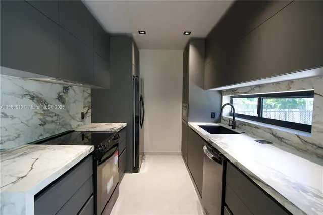 a kitchen with granite countertop a sink stove and cabinets