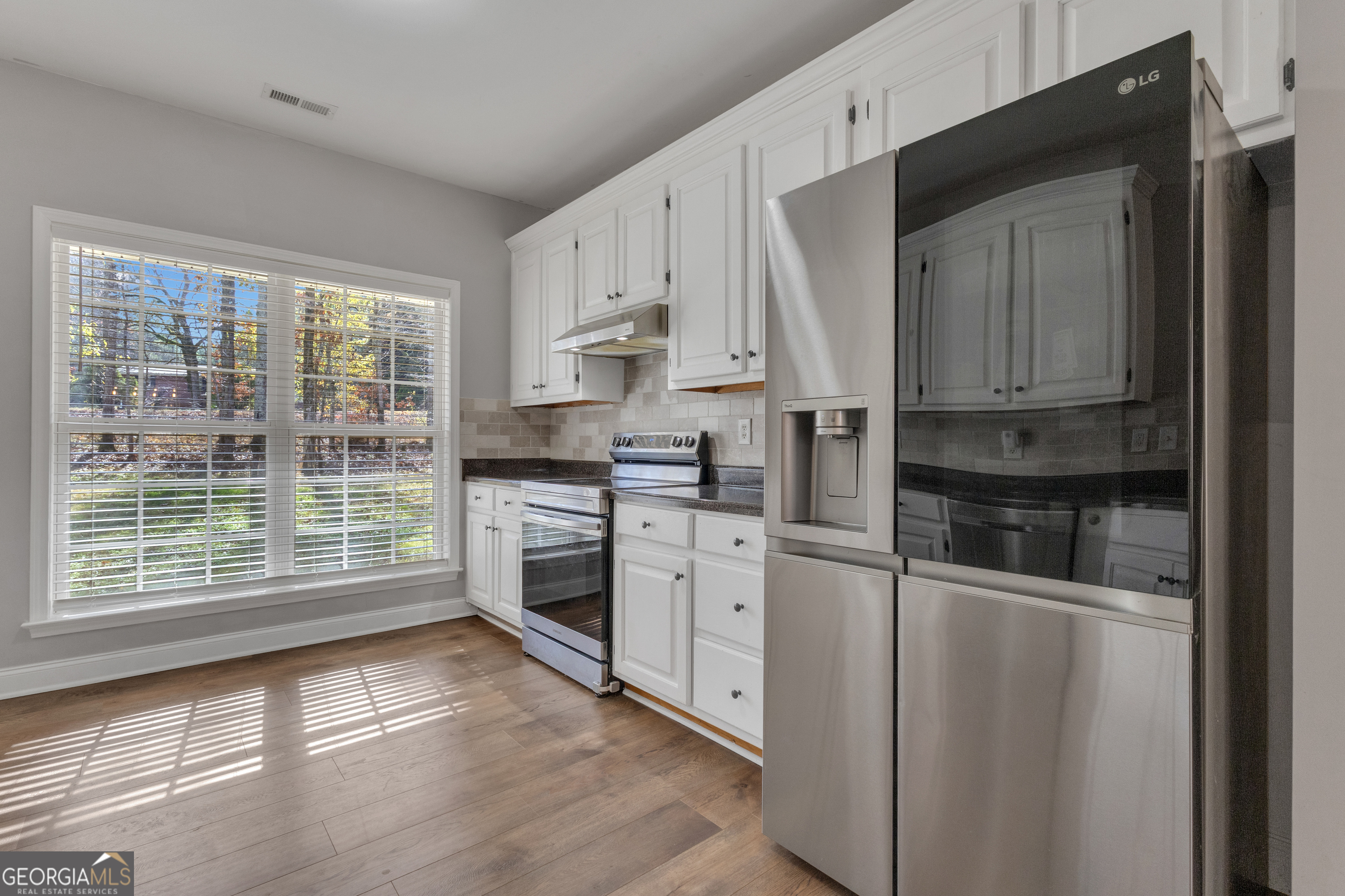 1135 Baptist Camp Road Griffin, GA 30223 - Photo 17 of 54 a kitchen with white cabinets and white appliances