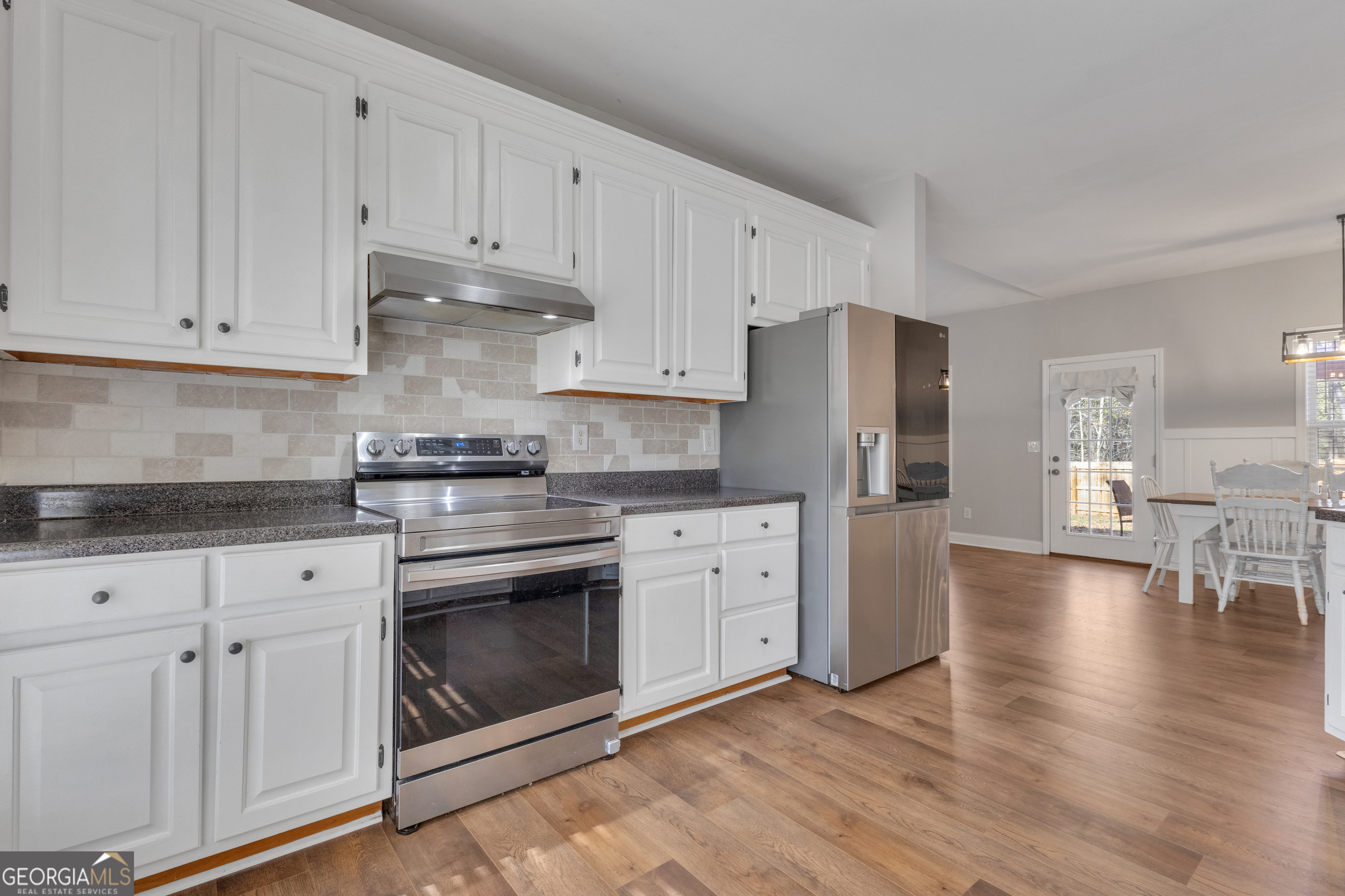 1135 Baptist Camp Road Griffin, GA 30223 - Photo 19 of 54 a kitchen with granite countertop white cabinets and stainless steel appliances