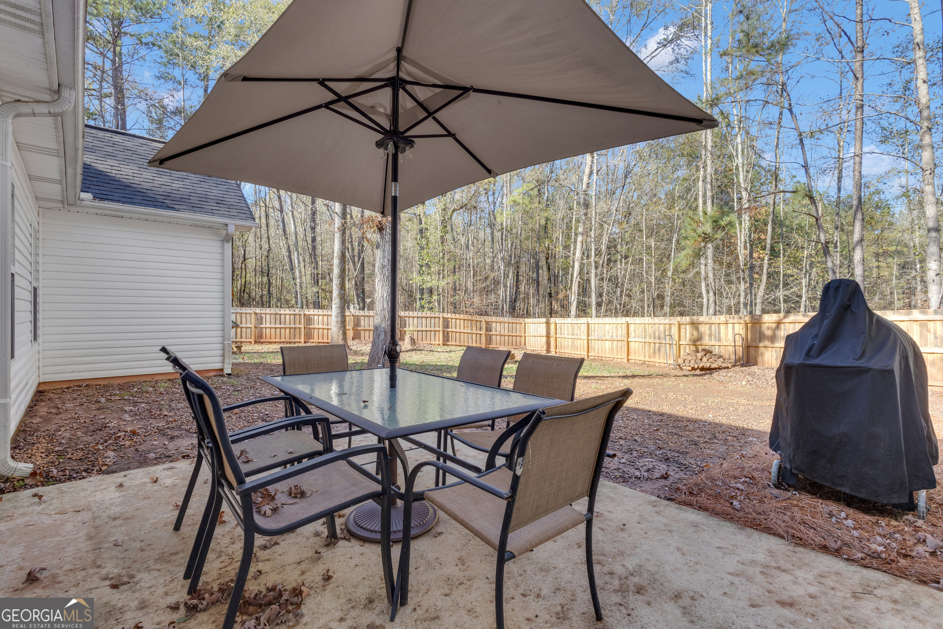1135 Baptist Camp Road Griffin, GA 30223 - Photo 42 of 54 a view of a patio with a table and chairs under an umbrella