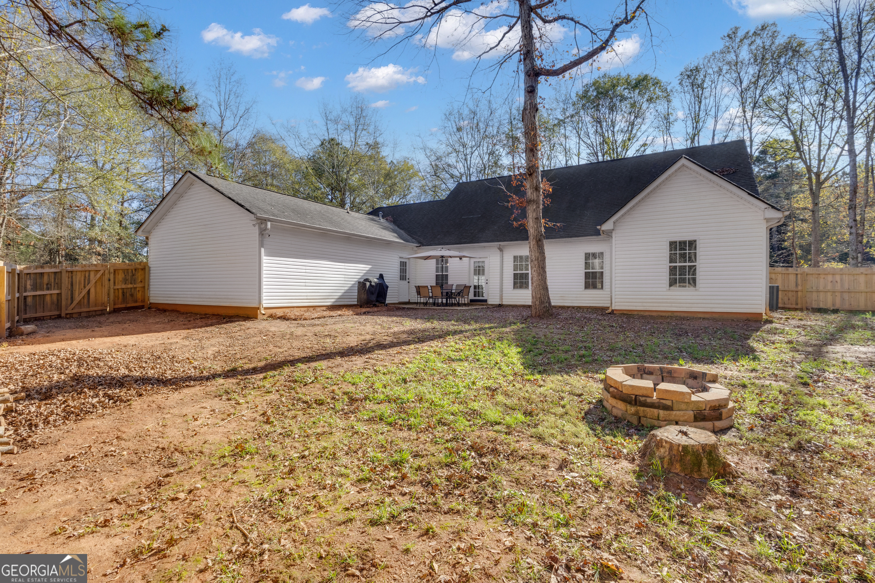 1135 Baptist Camp Road Griffin, GA 30223 - Photo 44 of 54 a backyard of a house with table and chairs under an umbrella