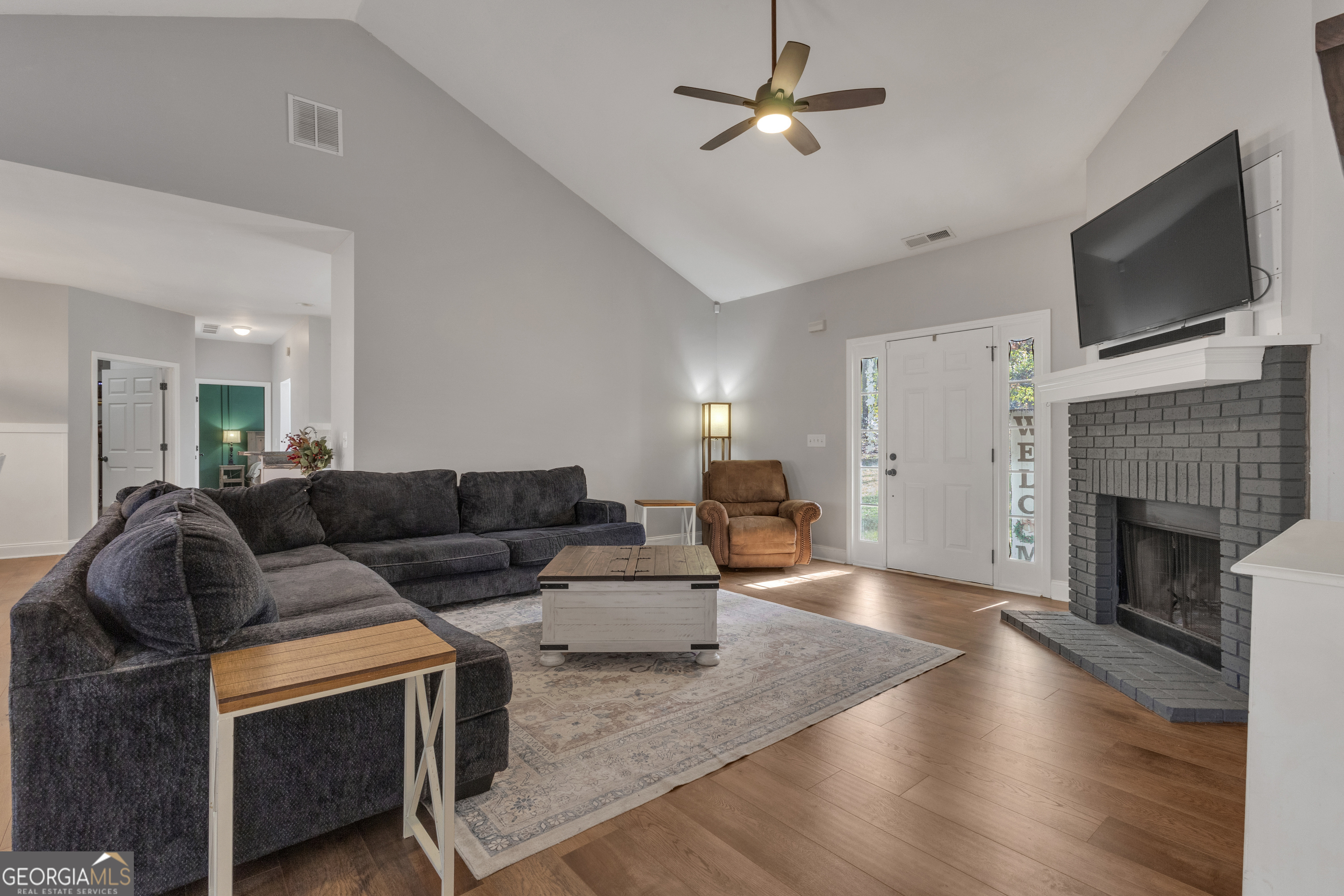 1135 Baptist Camp Road Griffin, GA 30223 - Photo 8 of 54 a living room with furniture a flat screen tv and a fireplace