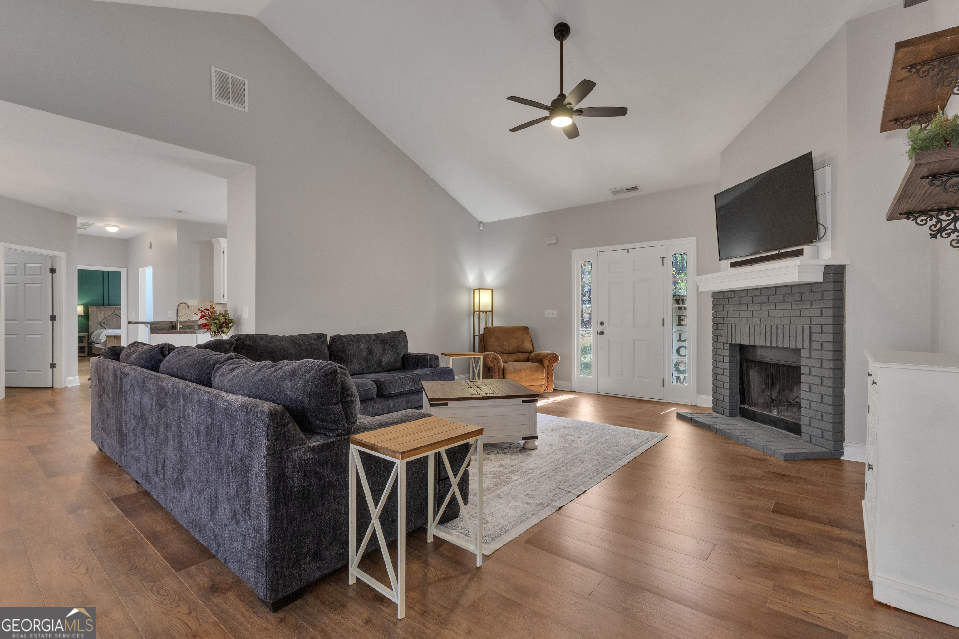 1135 Baptist Camp Road Griffin, GA 30223 - Photo 9 of 54 a living room with furniture a fireplace and a flat screen tv