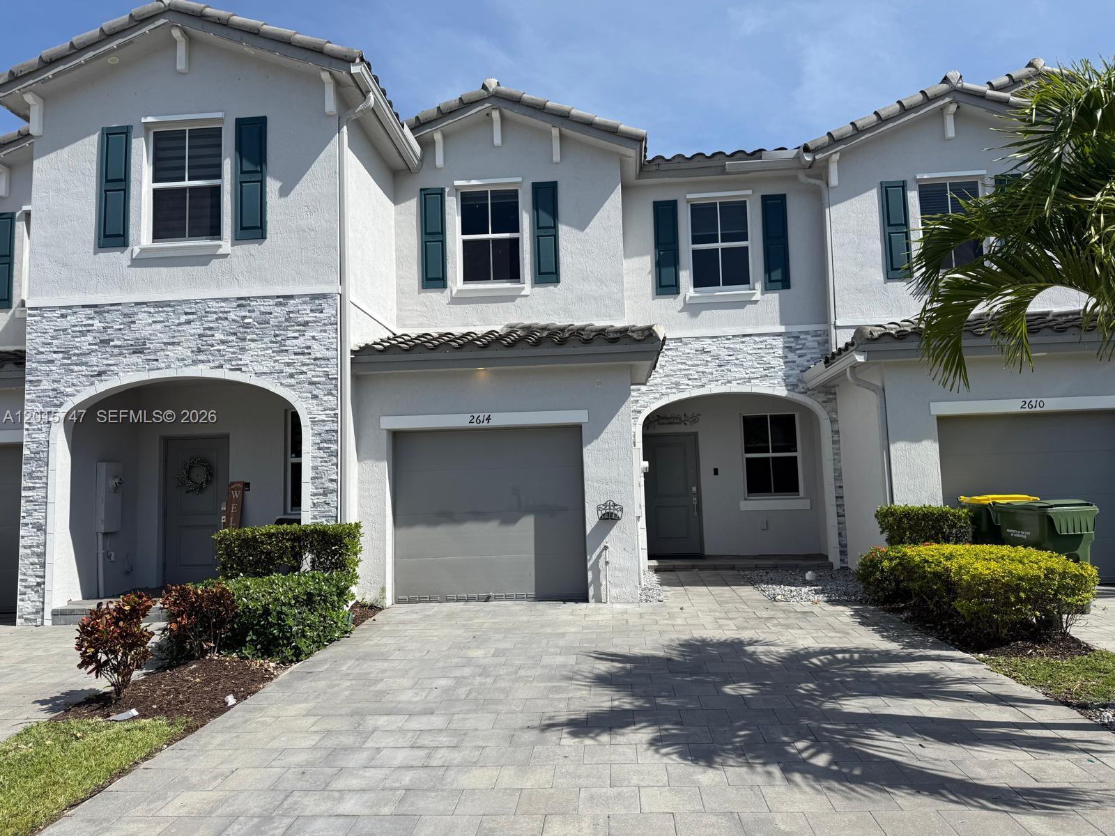 a front view of a house with yard and parking