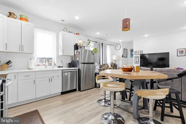 a kitchen with a dining table chairs stove and refrigerator