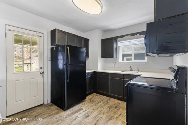 a kitchen with a refrigerator sink and cabinets