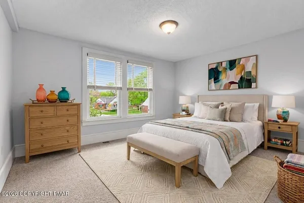 a spacious bedroom with a bed and a window