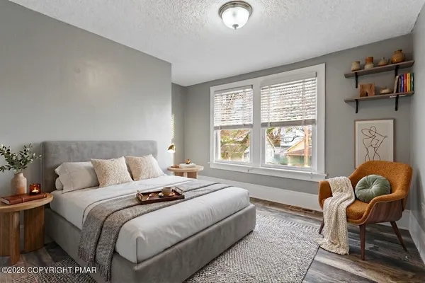a bedroom with bed chair and window