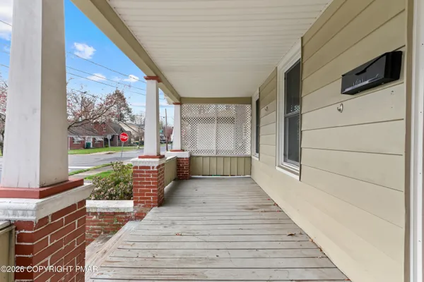 a porch with wooden floor and furniture