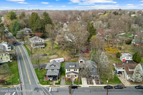 an aerial view of multiple houses with a street