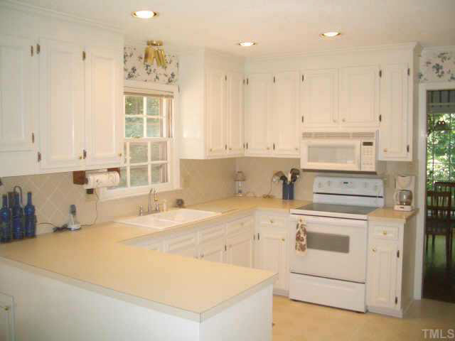 2721 Salisbury Raleigh, NC 27613 - Photo 3 of 10 a kitchen with a stove a sink and a refrigerator