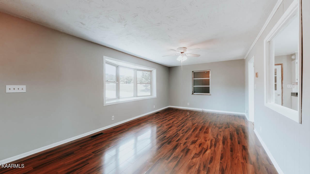 10008 Rutledge Pike Corryton, TN 37721 - Photo 3 of 30 a view of an empty room with wooden floor and a window