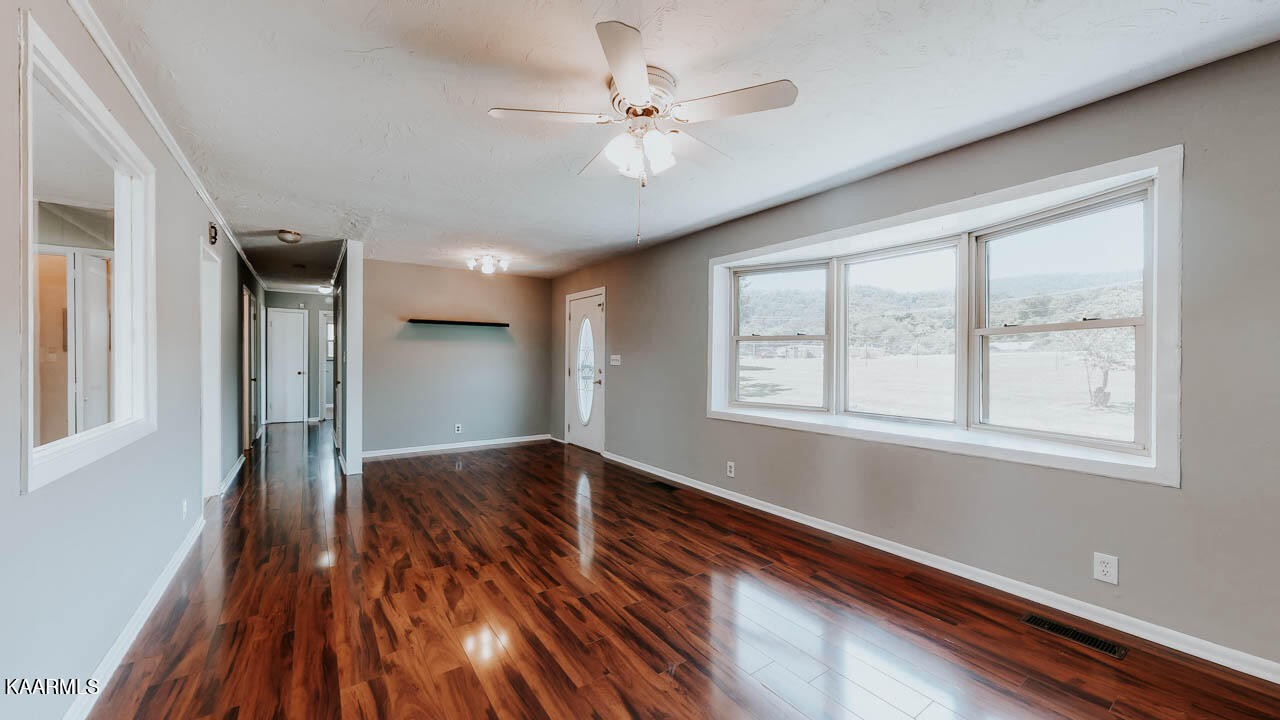 10008 Rutledge Pike Corryton, TN 37721 - Photo 4 of 30 a view of an empty room with wooden floor and a window