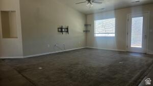 357 East 860 North Hurricane, UT 84737 - Photo 2 of 19 Spacious room featuring vaulted ceilings, a ceiling fan with integrated lighting, dark carpeting, and a glass-paneled exterior door