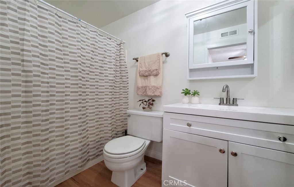 1182 North Sunflower Avenue Covina, CA 91724 - Photo 15 of 20 a bathroom with a toilet a sink a mirror and vanity