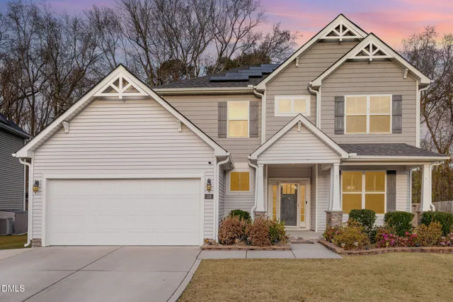 a front view of a house with a yard and seating space