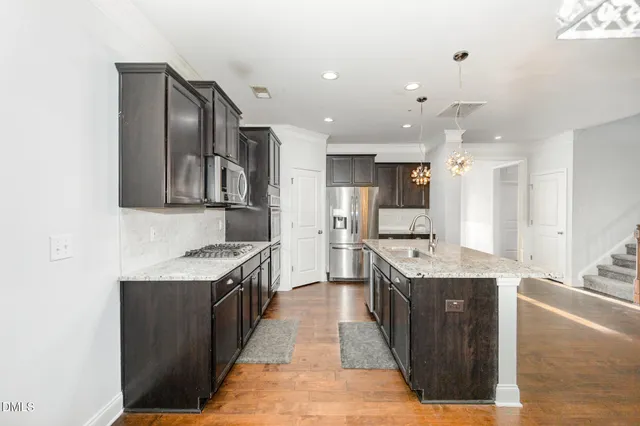 a kitchen with stainless steel appliances granite countertop a sink stove and refrigerator