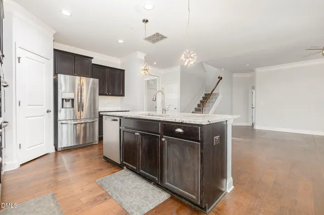 a kitchen with stainless steel appliances granite countertop a sink a stove and a refrigerator