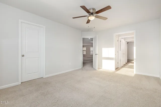 an empty room with a window and a ceiling fan