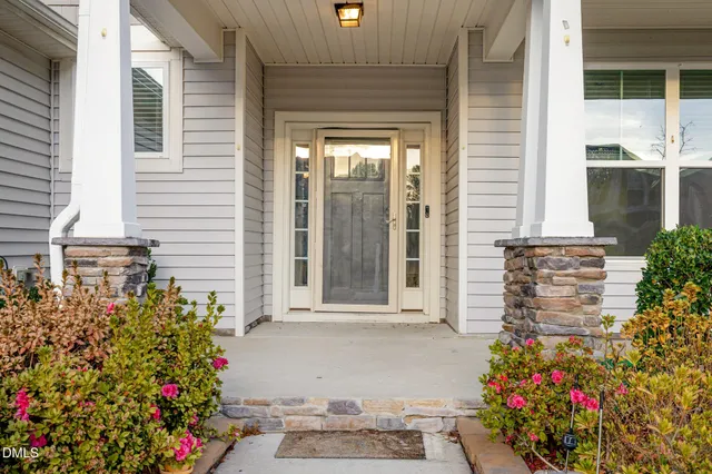 a view of a house with a yard and potted plants