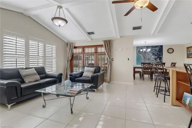 a living room with furniture a dining table and a large window