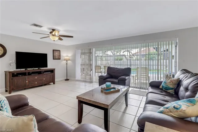 a living room with furniture a flat screen tv and a large window