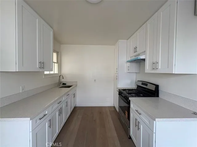 a kitchen with stainless steel appliances a stove a sink and cabinets