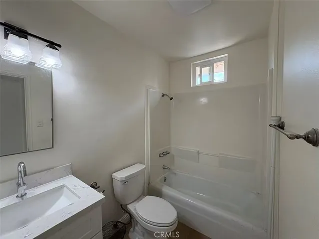 a bathroom with a toilet sink vanity and shower