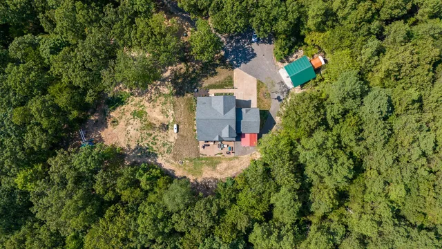 an aerial view of a house with a yard and trees
