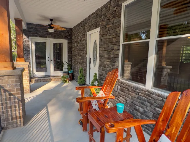 a view of a patio with table and chairs with wooden floor and fence