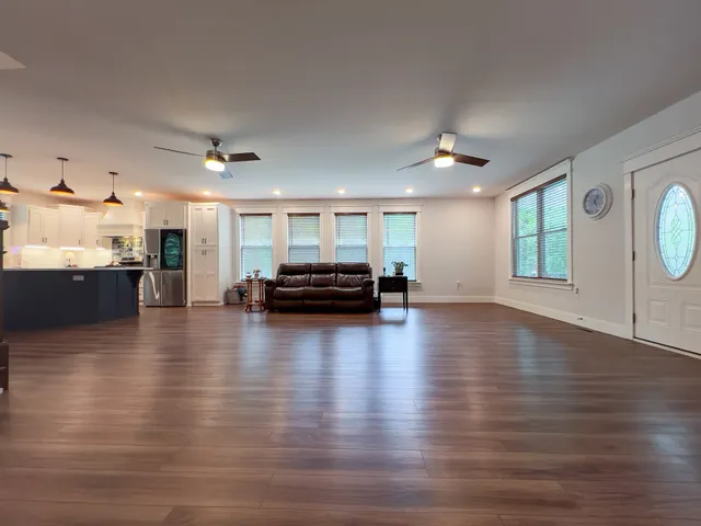 a view of a livingroom with furniture hardwood floor and a kitchen