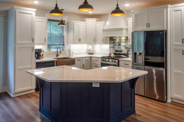 a kitchen with kitchen island a sink appliances and cabinets