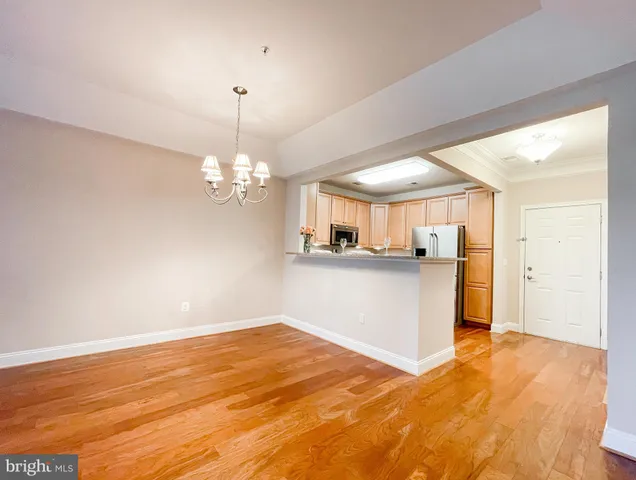 a view of a kitchen with wooden floor and a ceiling fan