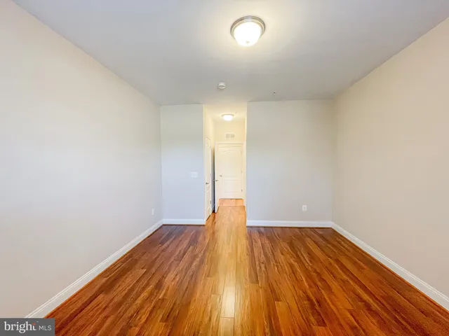 a view of a room with wooden floor and white walls