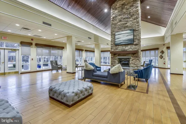 a living room with furniture flat screen tv and large window